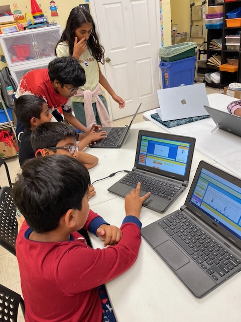A group of children working side by side in the game editor.